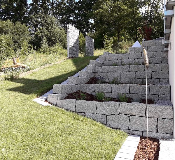 Gartenmauer aus Pflastersteinen und Metall als Sichtschutz
