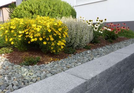 Blumenbeet an Steinmauer